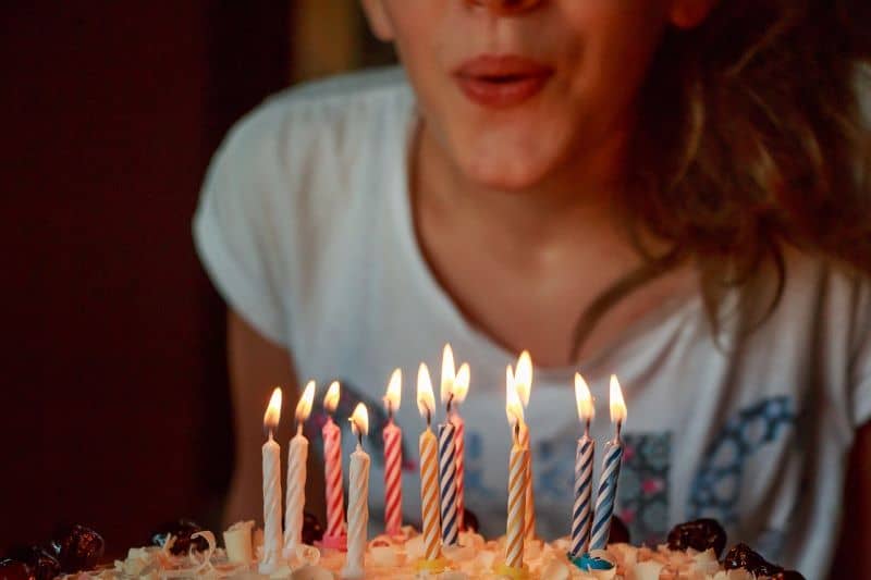 A woman blowing a birthday cake